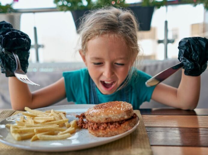 child eats a Burger in a restaurant