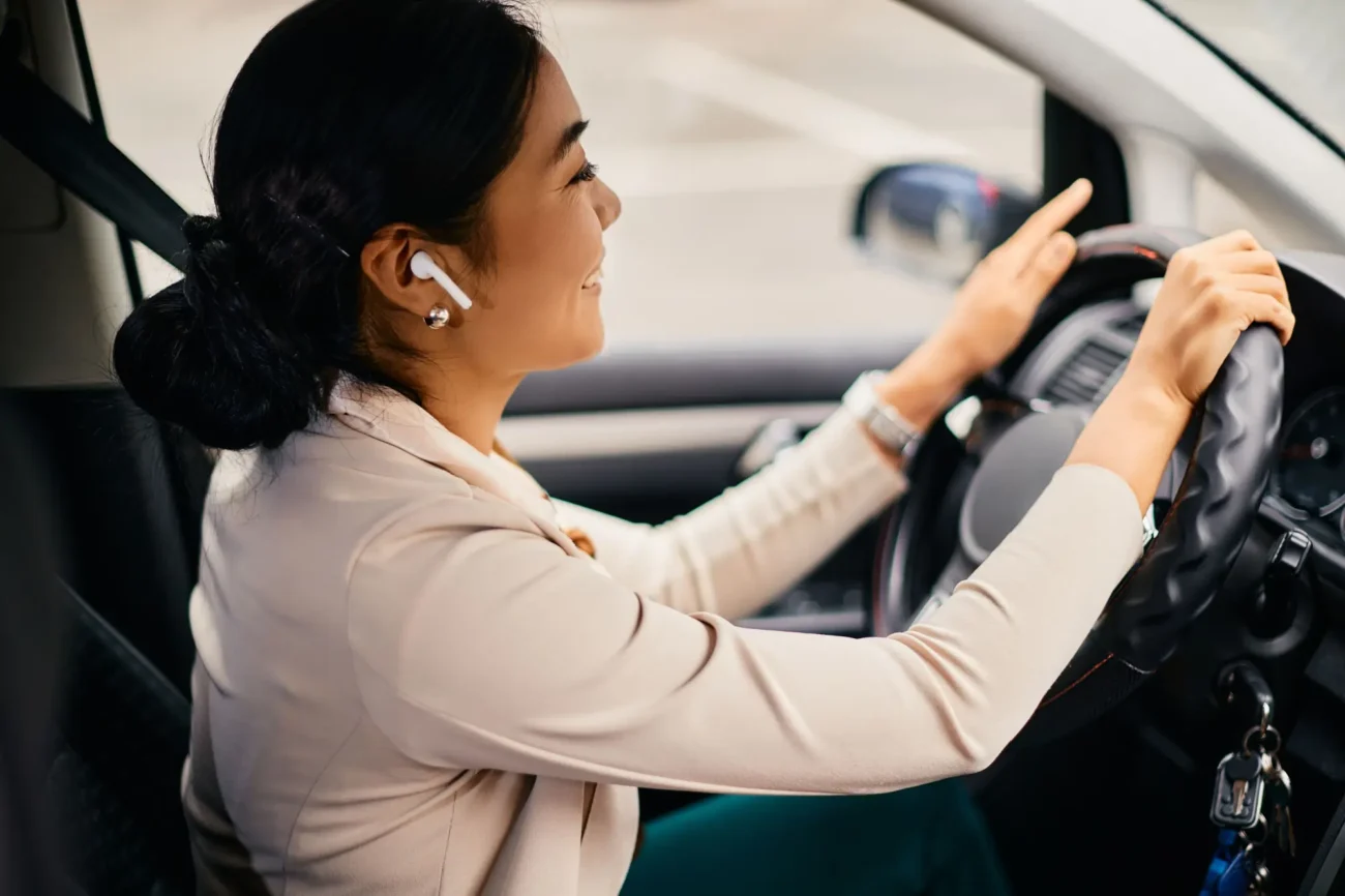 žena se sluchátky řídí auto