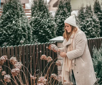 žena na zahradě u zmrzlé rostliny