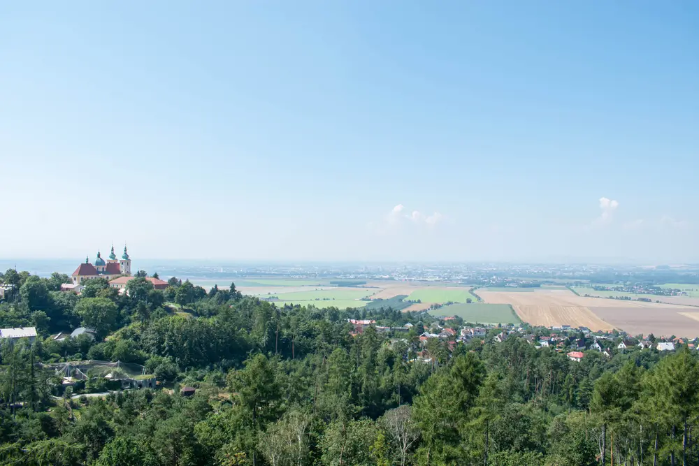 Záběr na krajinu. Po levé straně se vypíná bazilika na Svatém Kopečku u Olomouce. 