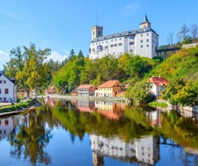 Hrad Rožmberk nad malebnou krajinou a řekou Vltava.