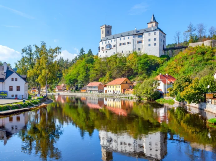 Hrad Rožmberk nad malebnou krajinou a řekou Vltava.