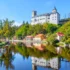 Hrad Rožmberk nad malebnou krajinou a řekou Vltava.