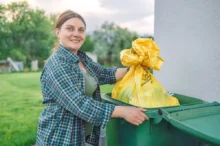 Žena vyhazuje odpad do popelnice.