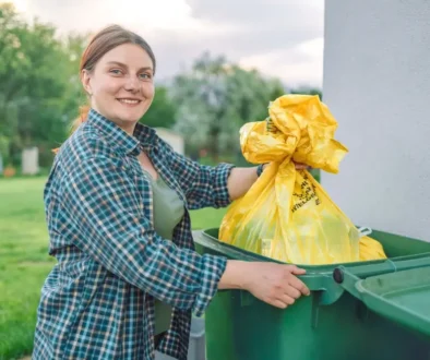 Žena vyhazuje odpad do popelnice.