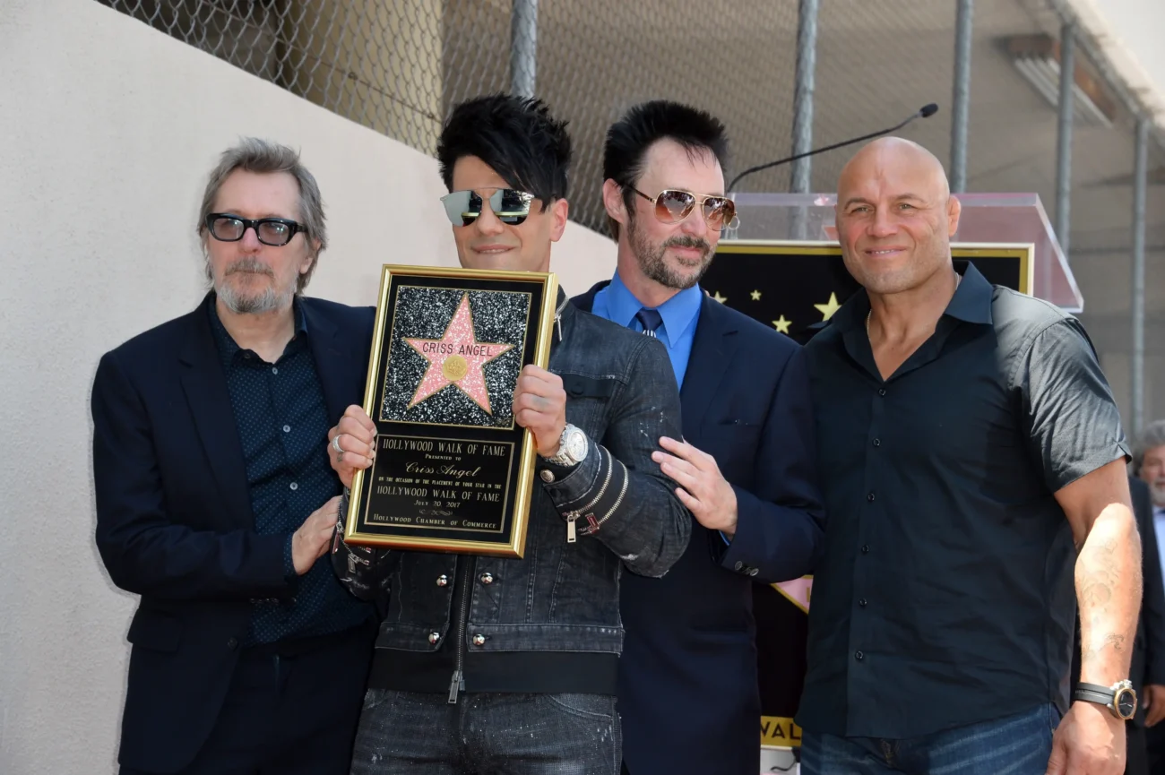 Criss Angel pózuje na chodníku slávy společně s dalšími lidmi.